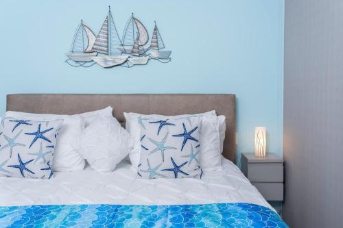 a bedroom with a bed with blue and white pillows at Casa Cabo - THE BEST, fully equipped luxurious brand new condo in Cabo San Lucas