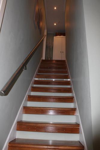 a stairway with white and wooden stairs and a kitchen at Zimmer David in Cologne