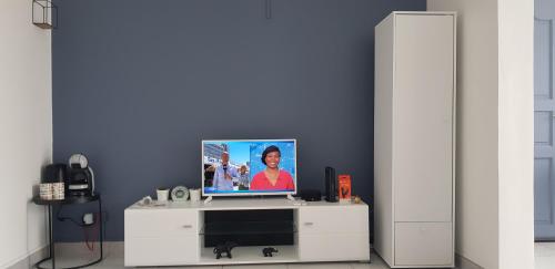 einen TV auf einem weißen Entertainment-Center in der Unterkunft studio Blue Honey 972 in Quartier Châteauboeuf