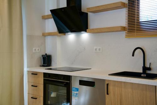 a kitchen with a sink and a stove at Wellgarden Holiday Villas, Türkbükü in Golturkbuku