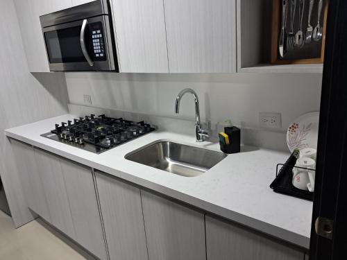 eine Küche mit Spüle und Mikrowelle in der Unterkunft En el Centro de Matagalpa in Matagalpa