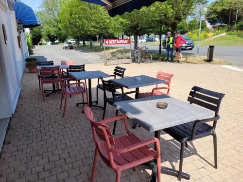 un groupe de tables et de chaises sur un trottoir dans l'établissement Le Saint Benoist, à Aizenay