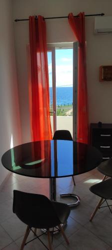 a glass table in a room with a view of the ocean at Casa fronte mare Torre sant'andrea in SantʼAndrea