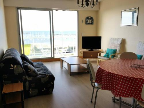un salon avec un canapé, une table et une télévision dans l'établissement Résidence Andréa Doria - Location de Vacances - PORNICHET - T3 - FACE PORT MAE-5861, à Pornichet