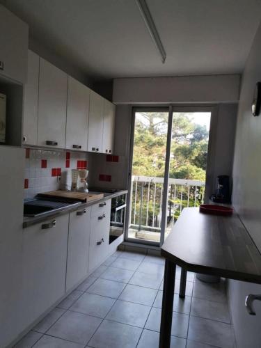 une cuisine avec des placards blancs et une grande fenêtre dans l'établissement Résidence Andréa Doria - Location de Vacances - PORNICHET - T3 - FACE PORT MAE-5861, à Pornichet