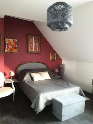 une chambre avec un lit et un mur rouge dans l'établissement Résidence Com-0894-st Andre Des Eaux - SAINT ANDRE DES EAUX - Maison avec piscine pour 6 personnes MAE-6331, à Saint-André-des-Eaux