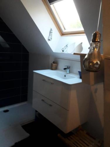 La salle de bains est pourvue d'un lavabo et d'une lucarne. dans l'établissement Résidence Com-0894-st Andre Des Eaux - SAINT ANDRE DES EAUX - Maison avec piscine pour 6 personnes MAE-6331, à Saint-André-des-Eaux
