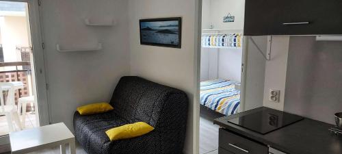 Cette petite chambre comprend une chaise et un lit. dans l'établissement Résidence Parc De La Plage - SAINT MARC SUR MER - Studio cabine pour 4 personnes à 50m de la plage MAE-6441, à Géraud