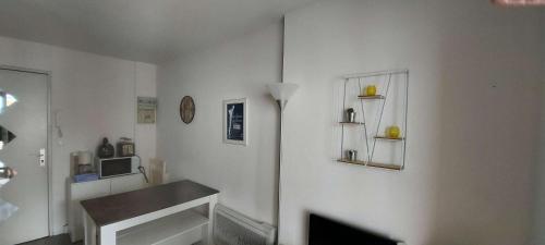 un salon blanc avec une table et une télévision dans l'établissement Résidence Parc De La Plage - SAINT MARC SUR MER - Studio cabine pour 4 personnes à 50m de la plage MAE-6441, à Géraud