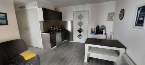 une petite cuisine avec une table dans une pièce dans l'établissement Résidence Parc De La Plage - SAINT MARC SUR MER - Studio cabine pour 4 personnes à 50m de la plage MAE-6441, à Géraud