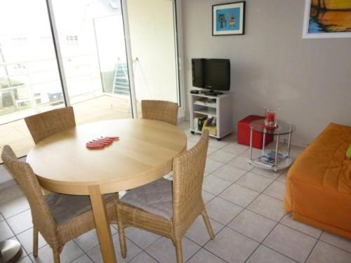 un salon avec une table, des chaises et une télévision dans l'établissement Résidence Argos - Location de Vacances - PORNICHET - 2 pièces - 021 - 60409 MAE-7411, à Pornichet