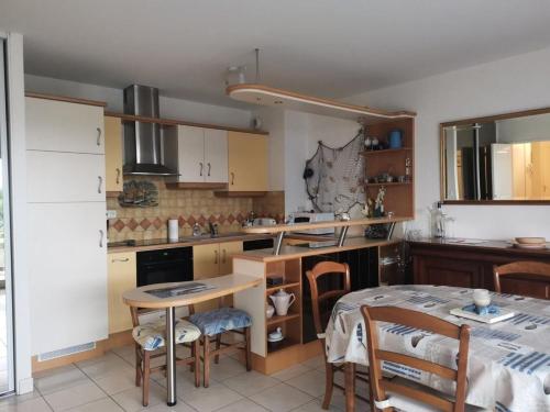 - une cuisine avec une table, une table et des chaises dans l'établissement Résidence Le Galatée - Location de Vacances - PORNICHET - proche place du marché MAE-7421, à Pornichet