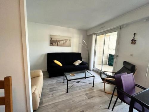 un salon avec un canapé noir et une table dans l'établissement Résidence Le Welcome - Location de Vacances - PORNICHET - T2 QUARTIER GARE MAE-7431, à Pornichet