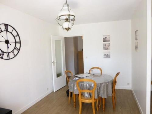 une salle à manger avec une table, des chaises et une horloge dans l'établissement Résidence Le Welcome - Location de Vacances - PORNICHET - T2 QUARTIER GARE MAE-7431, à Pornichet