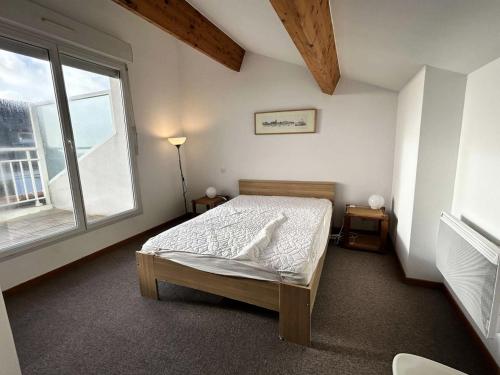 une chambre avec un lit et une grande fenêtre dans l'établissement Résidence Pie-11-pornichet - Location de Vacances - PORNICHET - Maison-057-60629 MAE-7441, à Pornichet