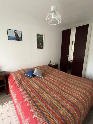 - une chambre avec un grand lit et un couvre-lit coloré dans l'établissement Résidence Le Concorde - PORNICHET - APPARTEMENT VUE MER PROCHE QUARTIER GARE MAE-7461, à Pornichet