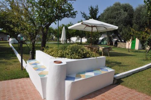 a bench with an umbrella and a table at Hotel Savoia in Procida