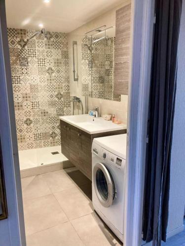 une salle de bain avec une machine à laver et un lavabo dans l'établissement Résidence Le Brahms - PORNICHET - PROCHE PLAGE ET COMMERCES MAE-7521, à Pornichet