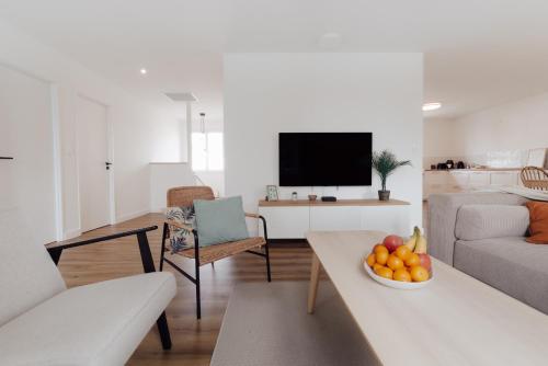 un salon avec un canapé et une table avec un bol de fruits dans l'établissement Maison familiale avec jardin proche de La Rochelle, à Nieul-sur-Mer