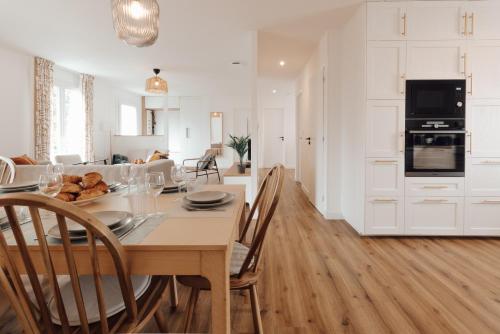 une cuisine et une salle à manger avec une table et des chaises dans l'établissement Maison familiale avec jardin proche de La Rochelle, à Nieul-sur-Mer