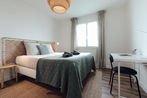 - une chambre avec un lit, un bureau et une chaise dans l'établissement Maison familiale avec jardin proche de La Rochelle, à Nieul-sur-Mer