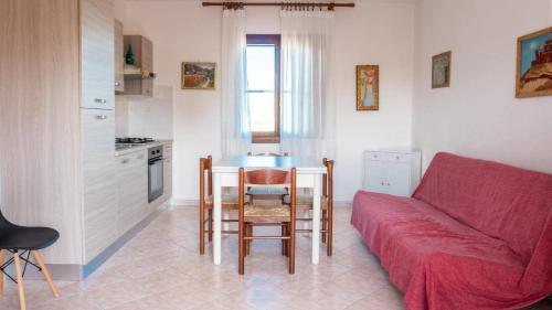 a living room with a red couch and a table at Casa Tavolara in San Teodoro