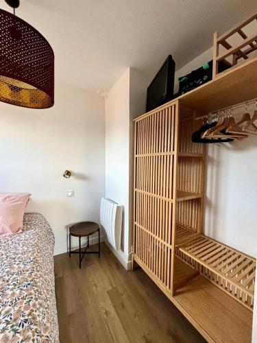 - une chambre avec un lit et une étagère en bois dans l'établissement Résidence Le Monaco - PORNICHET - APPARTEMENT VUE MER MAE-7531, à Pornichet