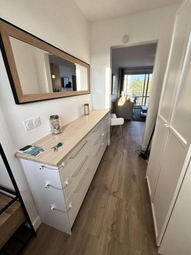 La salle de bains est pourvue d'une commode avec un miroir mural. dans l'établissement Résidence Le Monaco - PORNICHET - APPARTEMENT VUE MER MAE-7531, à Pornichet