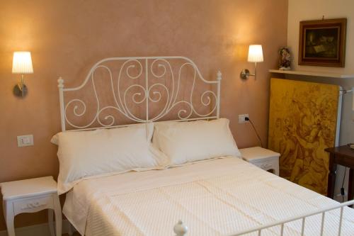 1 dormitorio con 1 cama blanca con 2 mesas y 2 lámparas en B&B I Propilei di San Girolamo en Rímini