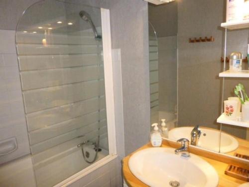 une salle de bain avec un lavabo et une douche en verre dans l'établissement Résidence Casa Del Mar - Location de Vacances - LA BAULE FACE MER MAE-0391, à La Baule