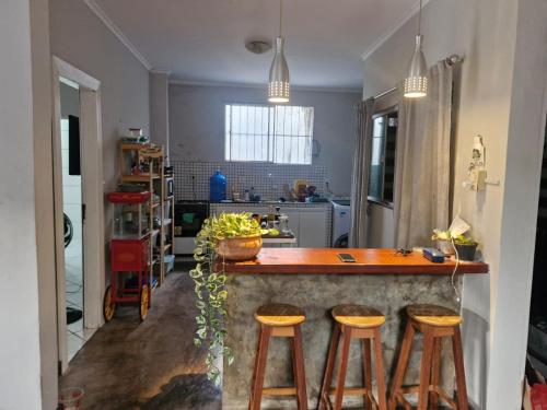 a kitchen with two bar stools and a counter top at Loft de Quarto e Sala em Vila in Belém