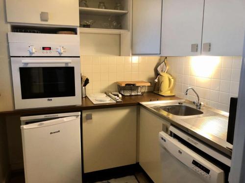 une petite cuisine avec un micro-ondes et un évier dans l'établissement Résidence Le Clipper B - La Baule - Appartement Face Mer MAE-2451, à La Baule-les-Pins