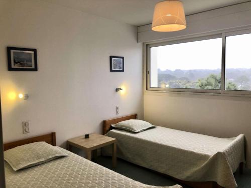 deux lits dans une chambre avec une fenêtre dans l'établissement Résidence Le Clipper B - La Baule - Appartement Face Mer MAE-2451, à La Baule-les-Pins