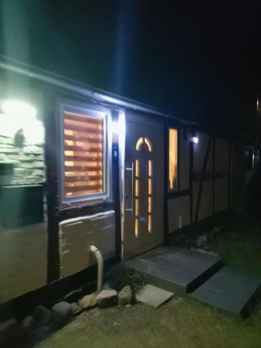 a house with a door and a window at night at Privatzimmer Zur alten Salzstraße in Schnakenbek