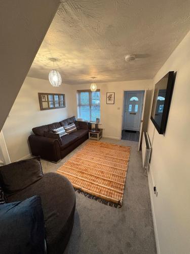 a living room with a couch and a rug at Northampton 2 King Bed SKY TV Driveway Earls Barton in Earls Barton