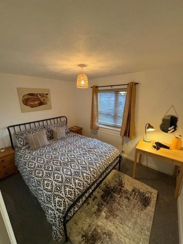 a bedroom with a bed and a desk and a window at Northampton 2 King Bed SKY TV Driveway Earls Barton in Earls Barton