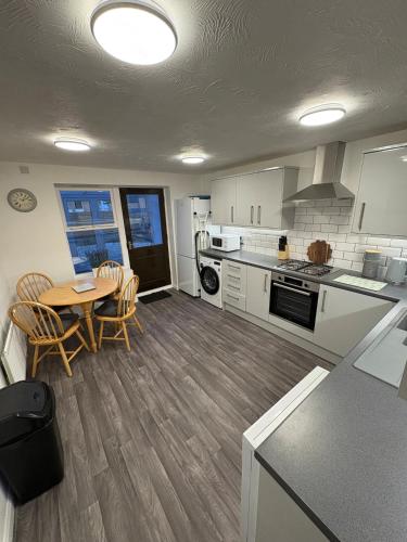 a kitchen with a table and chairs in a kitchen at Northampton 2 King Bed SKY TV Driveway Earls Barton in Earls Barton