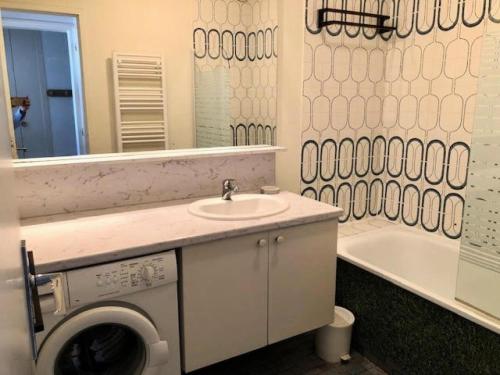 une salle de bain avec un lavabo et une machine à laver dans l'établissement Résidence Britania - Location de Vacances - LA BAULE - T2 FACE MER - IMMEUBLES EN VAGUES MAE-2901, à La Baule-les-Pins