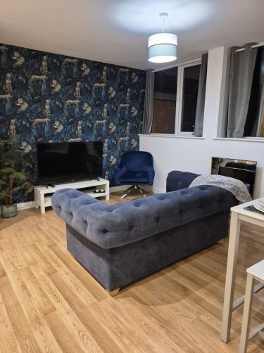 a living room with a couch and a television at Sapphire Luxe- Basingstoke Sleeps 4 with Free Parking in Basingstoke