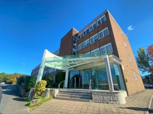 a large brick building with a staircase in front of it at Sapphire Luxe- Basingstoke Sleeps 4 with Free Parking in Basingstoke