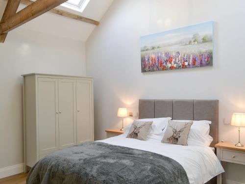 a bedroom with a bed and a painting on the wall at The Hemmel in Greenhaugh