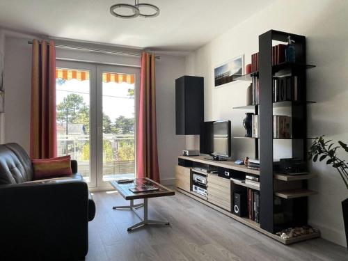 un salon avec un canapé et une télévision dans l'établissement Résidence Les Ibis - PORNICHET CENTRE GARE MAE-2951, à Pornichet