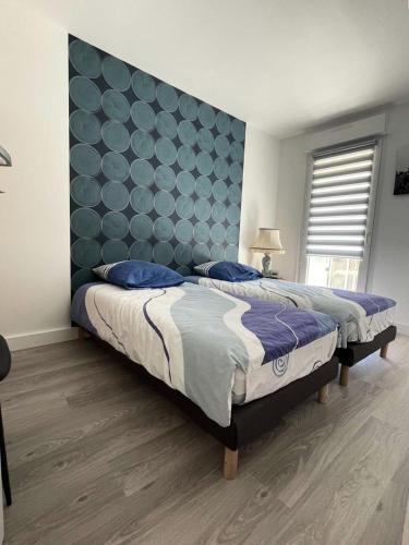 une chambre avec deux lits et une grande tête de lit bleue dans l'établissement Résidence Les Ibis - PORNICHET CENTRE GARE MAE-2951, à Pornichet