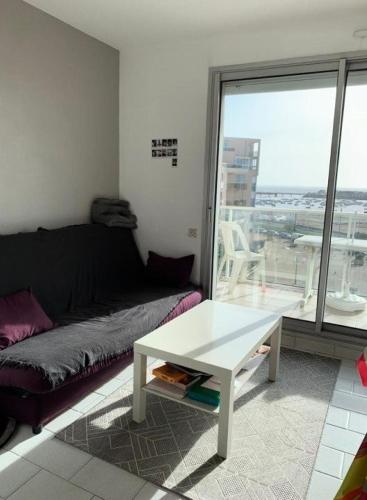 un salon avec un canapé et une table basse dans l'établissement Résidence Les Marines - Location de Vacances - PORNICHET -T2 FACE MER OCEANES MAE-2921, à Pornichet