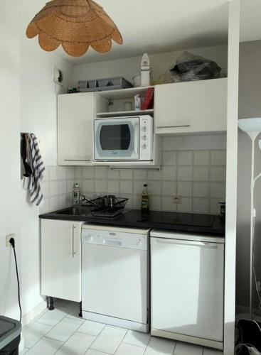 Il comprend une cuisine équipée d'appareils électroménagers blancs et d'un four micro-ondes. dans l'établissement Résidence Les Marines - Location de Vacances - PORNICHET -T2 FACE MER OCEANES MAE-2921, à Pornichet