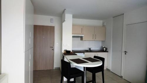 une cuisine avec une table et des chaises dans une pièce dans l'établissement Résidence Estelle - PORNICHET - SAINTE MARGUERITE - STUDIO MAE-9711, à Pornichet