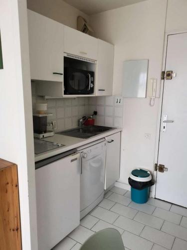 une cuisine blanche avec un évier et un micro-ondes dans l'établissement Résidence Les Marines - Location de Vacances - PORNICHET - Quartier des Océanes MAE-9691, à Pornichet
