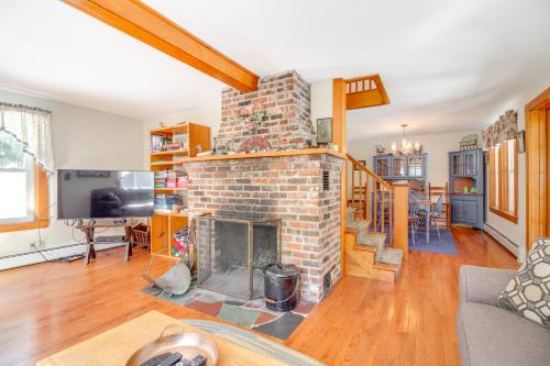 an open living room with a brick fireplace at Swim, Ski and Sip Lakefront Retreat in Plymouth in Plymouth