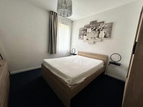 une chambre avec un lit et un lustre dans l'établissement Résidence Ker Juliette - Pornichet - Résidence Ker Juliette MAE-9721, à Pornichet