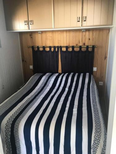 un lit avec une tête de lit noire dans une chambre dans l'établissement Résidence Les Océanes - Location de Vacances - PORNICHET-Studio cabine confort-BRIQU-65989 MAE-9701, à Pornichet